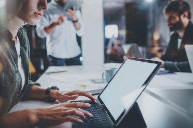 Çalışma arkadaşları fotoğraf işlemek. Genç kız gece modern ofis çatı katında birlikte meslektaşları ile çalışma. Ekip çalışması kavramı. Arka plan bulanık. Horizontal.Cropped.