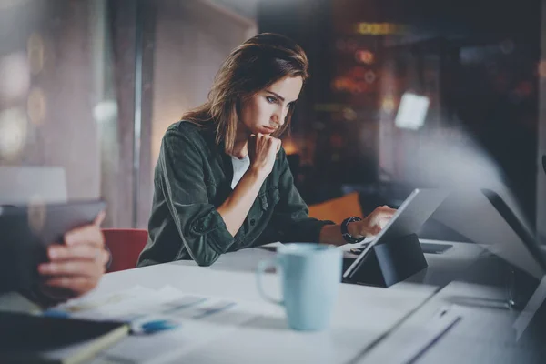 Colaboradores proceso de trabajo photo.Young mujer trabajando junto con colegas en la noche moderna oficina loft.Teamwork concept.Blurred fonground.Horizontal . — Foto de Stock