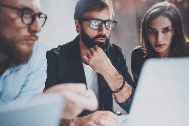 Üç genç iş arkadaşlarınızla birlikte modern coworking Studio dizüstü bilgisayarlarda çalışma gece. Dizüstü bilgisayar kullanarak gözlüklü adam. Horizontal.Blurred arka plan.