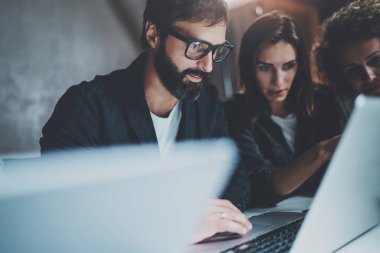 Çalışma süreci fotoğraf. Genç arkadaşları birlikte gece modern ofis çatı katında çalışma grubu. Arka plan bulanık. Yatay.