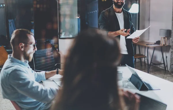 Ontmoeting van mensen bedrijfsconcept. Jonge collega's werken op kantoor van de nacht. Horizontaal, fakkels effect. Onscherpe achtergrond. Bijgesneden. — Stockfoto