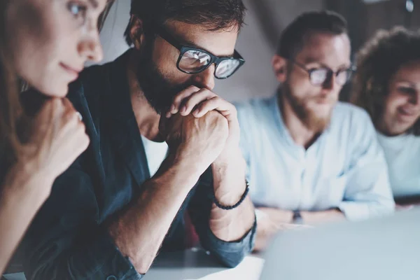 Groep van jonge ondernemers zijn op zoek naar een bedrijfsoplossing tijdens het werk op kantoor van de nacht. Mensen vergadering bedrijfsconcept. Onscherpe achtergrond. Horizontal.Cropped. — Stockfoto