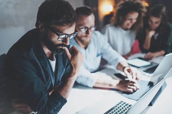 Teamwork concept. Projectteam maken van gesprek in de vergaderzaal op kantoor van de nacht. Mensen met behulp van laptops en gadgets. Horizontal.Blurred achtergrond. Fakkels effect. — Stockfoto