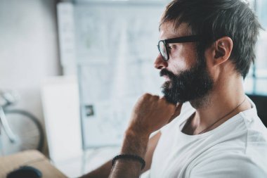 Portre portre yakışıklı tasarımcı çalışma modern ofis loft, sakallı. Yatay. Arka plan bulanık.