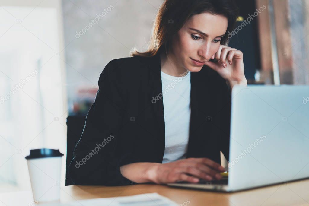 Portrait of Young beautiful businesswoman using laptop computer at modern office.Blurred background.Horizontal.