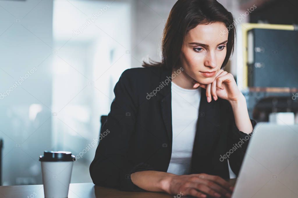 Young beautiful woman working at the modern office workplace. Horizontal. Blurred background.