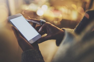 Kız gece atmosferik şehirde ekran smartphone cep telefonu ile işaret parmağı. Eller manifatura mesaj cep telefonu. Portre üzerinde arka plan bulanık. İşaret fişekleri, bokeh etkileri.