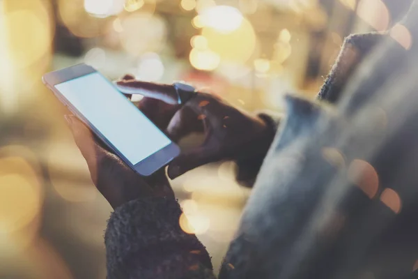 Chica señalando el dedo en el teléfono inteligente de la pantalla en la ciudad atmosférica de la noche.Manos femeninas mensajes de texto teléfono móvil.Primer plano sobre fondo borroso. . —  Fotos de Stock