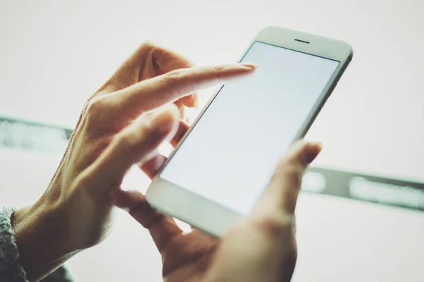 Ragazza che punta il dito sullo schermo smartphone.Femmina mani sms messaggio cellulare phone.Close up su sfondo sfocato di colore chiaro . — Foto Stock