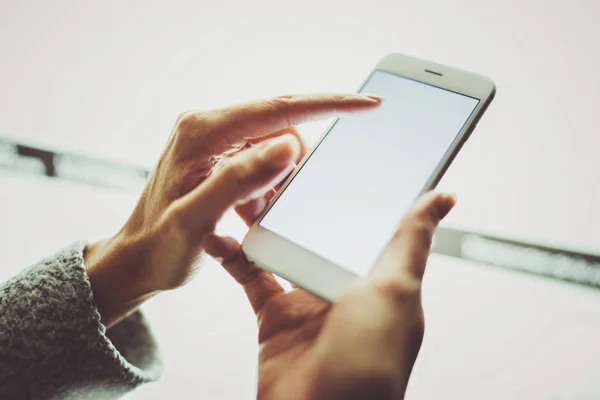 Dívka ukazující prst na obrazovku smartphone. Ženské ruce SMS zprávy mobilní telefon. Detailní záběr na rozmazané světlo barevné pozadí. — Stock fotografie
