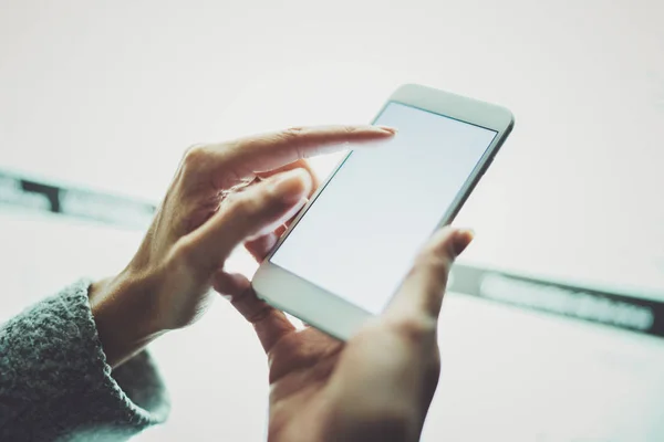 Lány ujját a képernyőn okostelefon. Női kezek SMS üzenetet mozgatható telefon. Közelkép a homályos fény színes háttérrel. — Stock Fotó