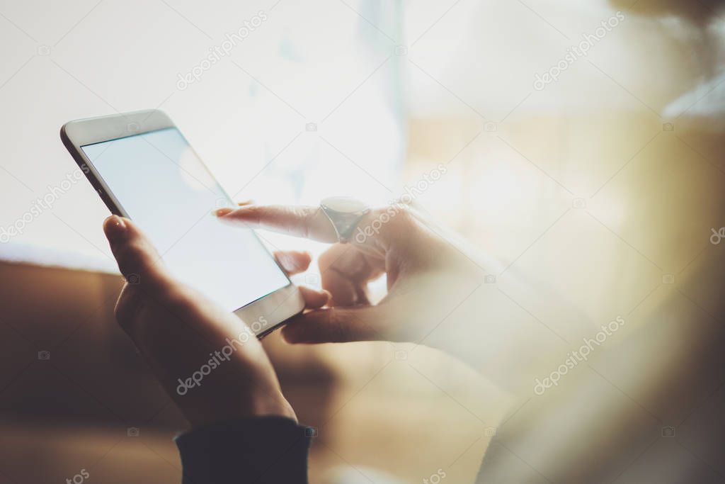 Girl pointing finger on screen smartphone in night atmospheric city.Female hands texting message mobile phone.Closeup on blurred background.Flares, bokeh effects.