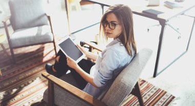 Yakışıklı genç sarışın gözlüklü ve güneşli işyeri elektronik dokunmatik tablet bilgisayar kullanarak. Yatay. Arka plan bulanık.