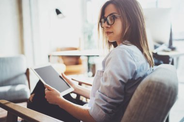 Yakışıklı genç sarışın gözlüklü ve güneşli işyeri elektronik dokunmatik tablet bilgisayar kullanarak. Yatay. Arka plan bulanık.