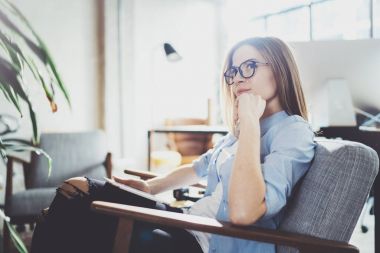 Yakışıklı genç sarışın gözlüklü ve güneşli işyeri elektronik dokunmatik tablet bilgisayar kullanarak. Yatay. Arka plan bulanık.