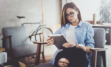 Dokunmatik yüzey modern coworking evinde kullanarak genç güzel kız öğrenci. Onun dijital tablet üzerinde çalışan serbest meslek sahibi kız.