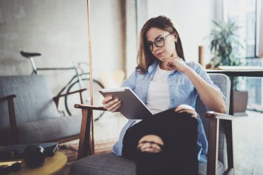 Genç güzel hipster kadın ile dokunmatik ekran cihaz modern coworking iş yerinde, tarama.