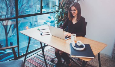 Gece ofiste iş işlemi sırasında yeni bir iş çözüm arayanlar için mobil dizüstü bilgisayar kullanan mutlu genç kadın. Arka plan bulanık.