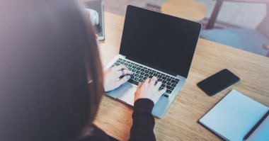 Modern ofiste dizüstü bilgisayar kullanan iş kadını. Arka plan bulanık. Yatay.