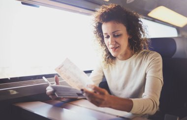 İş seyahat kavramı zevk. Smartphone, Window'u oturan tren seyahat eden genç güzel esmer turist kız bilet elele.