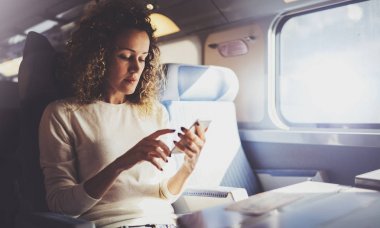 Seyahat kavramı zevk. Genç kadın turist smartphone kullanarak pencere oturan trenle seyahat güzel.