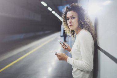 Güzel kız konuşma tatil seyahat için cep telefonu app kullanarak mutlu. Demiryolu tren istasyonu beklerken cep telefonuyla transit platformda güzel kadın.