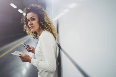 Güzel kız konuşma tatil seyahat için cep telefonu app kullanarak mutlu. Demiryolu tren istasyonu beklerken cep telefonuyla transit platformda güzel kadın.