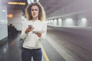 Güzel kız konuşma tatil seyahat için cep telefonu app kullanarak mutlu. Demiryolu tren istasyonu beklerken cep telefonuyla transit platformda güzel kadın.