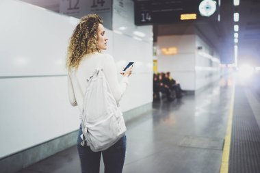 Güzel kız konuşma tatil seyahat için cep telefonu app kullanarak mutlu. Demiryolu tren istasyonu beklerken smartphone kullanarak transit platformda çekici kadın.