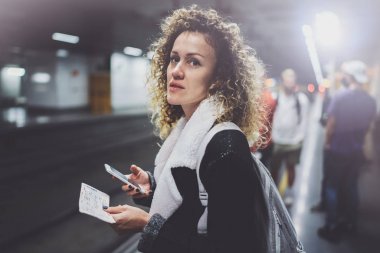 Sırt çantası için smartphone kullanarak transit platformda çekici kadın olun fotoğraf tren bilet metro istasyonu demiryolu tren beklerken.