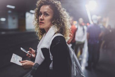 Sırt çantası için smartphone kullanarak transit platformda çekici kadın olun fotoğraf tren bilet metro istasyonu demiryolu tren beklerken.