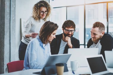 Ekip çalışması kavramı. Genç yaratıcı iş arkadaşlarınızla modern ofis yeni başlangıç projesi ile çalışma. Üç Kişilik grup masaüstü bilgisayardaki verileri analiz. Yatay, bulanık arka plan.