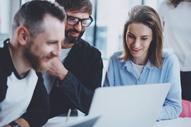 Ekip çalışması işlem kavramı. Mutlu arkadaşları yeni başlangıç proje ile güneşli ofiste çalışıyor. Yatay, bulanık arka plan.