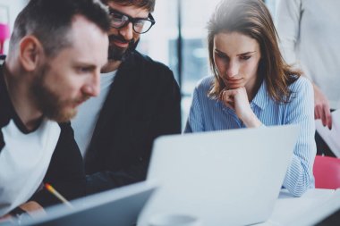 Ekip çalışması işlem kavramı. Mutlu arkadaşları yeni başlangıç proje ile güneşli ofiste çalışıyor. Yatay, bulanık arka plan.