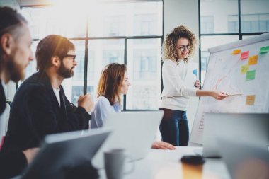 Genç arkadaşları birlikte yeni iş sunumu güneşli toplantı salonunda çalışıyor. Horizontal.Blurred arka plan.