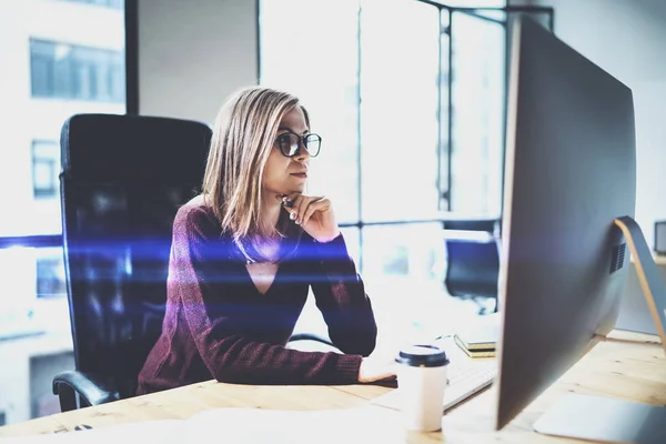Attraktiv ung affärskvinna använder stationär dator på moderna arbetsplats på kontoret. Suddig bakgrund. Horisontell. — Stockfoto