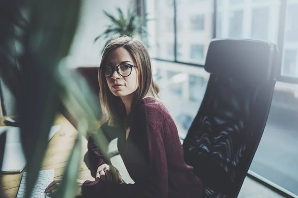 Attraktiv ung affärskvinna använder stationär dator på moderna arbetsplats på kontoret. Suddig bakgrund. Horisontell. — Stockfoto