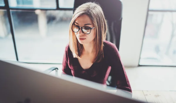 Attraktiv ung affärskvinna använder stationär dator på moderna arbetsplats på kontoret. Suddig bakgrund. Horisontell. — Stockfoto