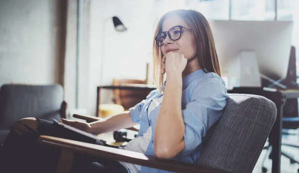 Joven hermosa estudiante usando almohadilla táctil en el moderno lugar de coworking. Freelancer chica trabajando en su tableta digital . — Foto de Stock