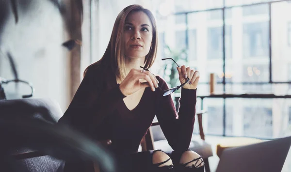 Vista de cerca de la joven hermosa mujer sentada en el cómodo sillón y el uso de la computadora portátil.Proceso de trabajo en el estudio de coworking. . —  Fotos de Stock