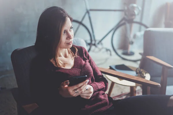 Blonde junge Frau mit modernem Handy in der Hand. Mädchen zeigt mit den Fingern auf leeren Touch-Handy-Bildschirm am sonnigen Coworking-Platz. horizontaler, verschwommener Hintergrund. — Stockfoto