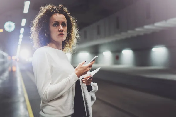 Mujer bonita en tránsito de viaje utilizando el teléfono inteligente, mientras que de pie en la estación de tren. Chica atractiva feliz utilizando la aplicación de teléfono móvil para la conversación en viajes de vacaciones . —  Fotos de Stock