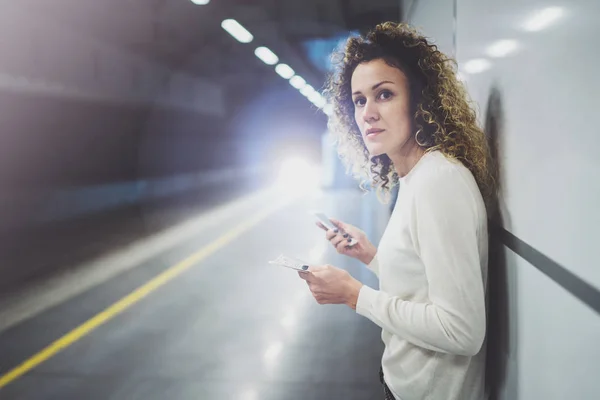 Hermosa chica feliz utilizando la aplicación de teléfono móvil para la conversación en viajes de vacaciones.Mujer bonita en la plataforma de tránsito utilizando el teléfono móvil mientras espera tren en la estación . —  Fotos de Stock