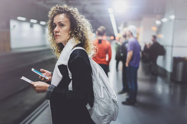 Femme attrayante avec sac à dos sur la plate-forme de transport en commun à l'aide d'un smartphone pour faire une photo du billet de train tout en attendant train ferroviaire sur la station de métro . — Photo