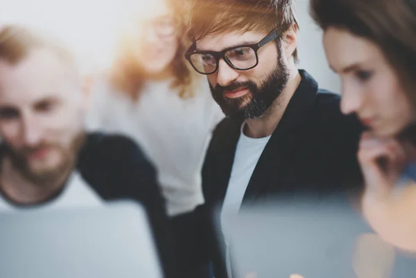 Gruppe junger Unternehmer sucht während der Arbeitszeit im sonnigen Büro nach einer Geschäftslösung. Geschäftsleute treffen sich mit concept.unscharf background.horizontal.flares. — Stockfoto