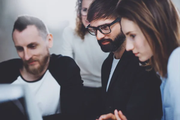 Groep van jonge ondernemers zijn op zoek naar een bedrijfsoplossing tijdens werktijd op zonnig kantoor. Mensen vergadering bedrijfsconcept. Onscherpe achtergrond. Horizontale. — Stockfoto