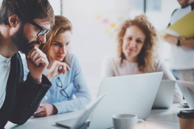 Ekip çalışması işlem kavramı. Mutlu arkadaşları yeni başlangıç proje ile güneşli ofiste çalışıyor. Yatay, bulanık arka plan.