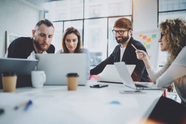 Çalışma süreci fotoğraf. Genç arkadaşları birlikte modern ofis çatı katında çalışma grubu. Arka plan bulanık. Yatay.