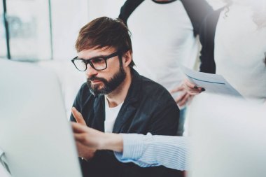 Modern ofis takım arkadaşları. Genç iş adamları ile yeni başlangıç güneşli toplantı salonunda çalışıyor. Arka plan bulanık.