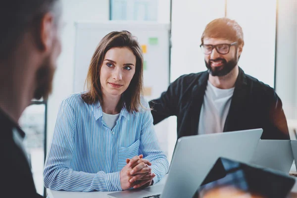 Tres compañeros de trabajo en el proceso de trabajo.Mujer joven que trabaja junto con su colega en la oficina moderna.Concepto de trabajo en equipo. Fondo borroso. Horizontal . — Foto de Stock